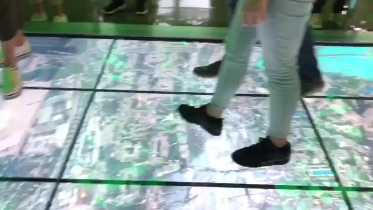 Visitors on the interactive glass-cracking floor at Burj Khalifa